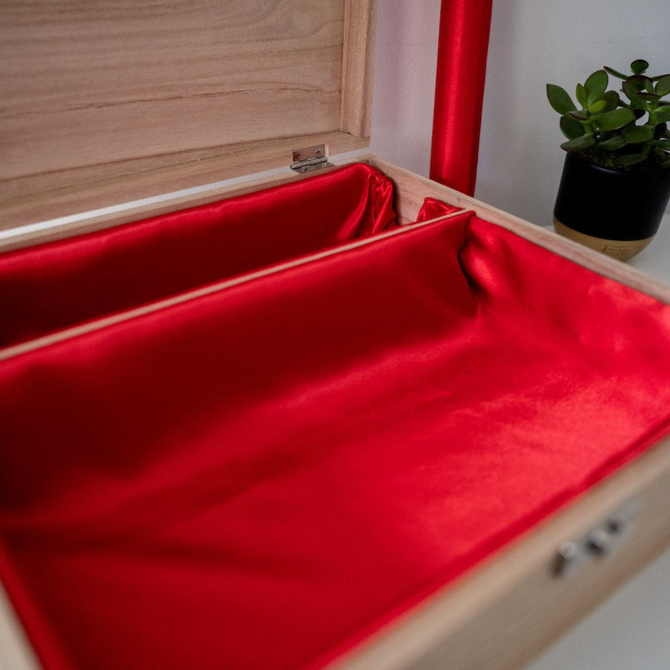 Open wooden box with red lining and bangle bar side angle