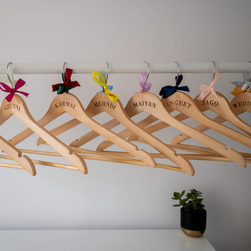 Personalised wooden hangers with a variety of coloured bows
