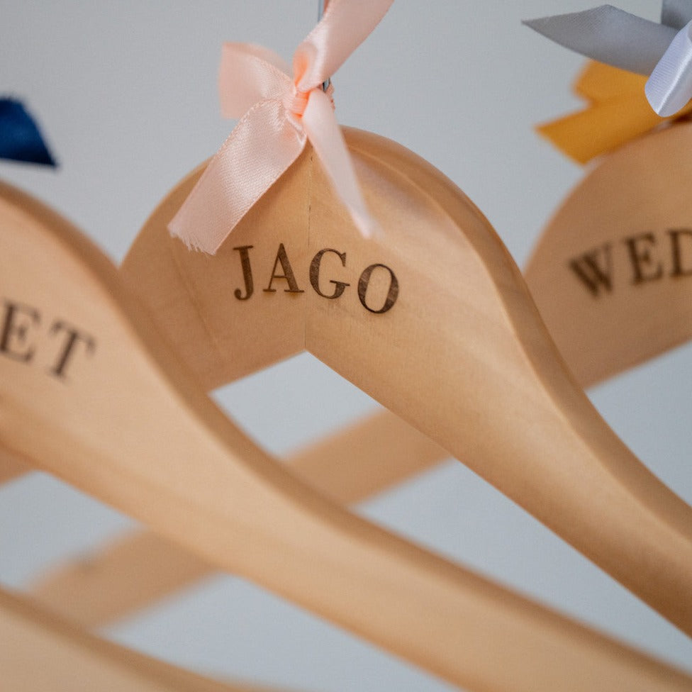 Personalised wooden hangers with a variety of coloured bows