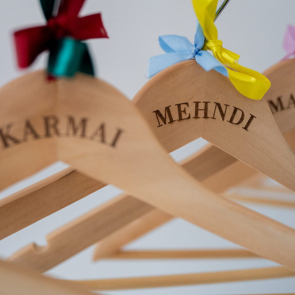 Personalised wooden hangers with a variety of coloured bows